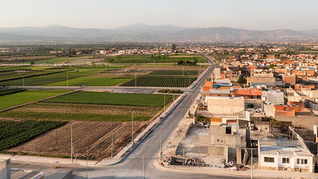 Calles nuevas junto a terrenos agrícolas en expansión urbana al norte de Cholula