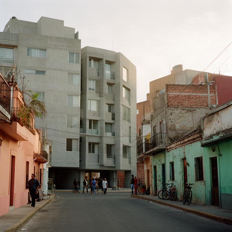Edificios de departamentos nuevos junto a casas antiguas en una calle de Cholula