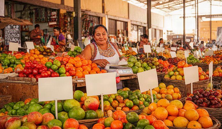 Puesto de frutas y verduras en un mercado de Puebla con precios visibles